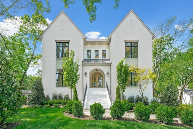 view of front of home featuring a front yard and french doors