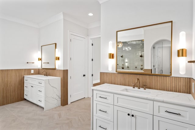 bathroom with vanity, wood walls, an enclosed shower, and ornamental molding