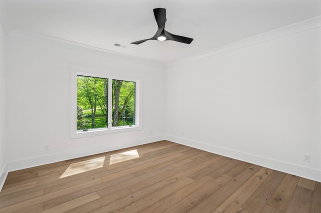 empty room with ceiling fan, ornamental molding, and light wood-type flooring