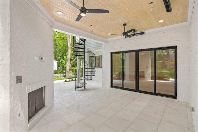 view of patio / terrace featuring exterior fireplace and ceiling fan