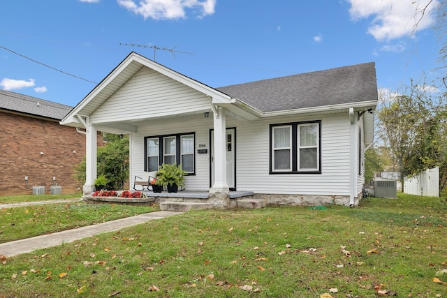 single story home with central air condition unit, a front lawn, and covered porch