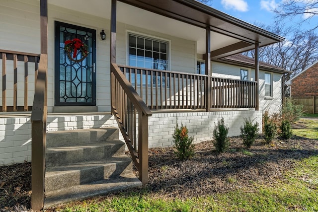 view of exterior entry featuring covered porch