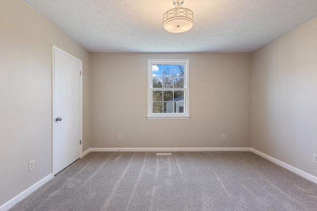 carpeted empty room featuring a textured ceiling