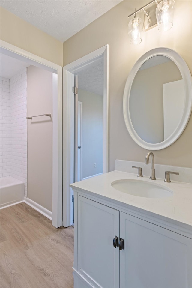 bathroom with vanity, a textured ceiling, and hardwood / wood-style flooring