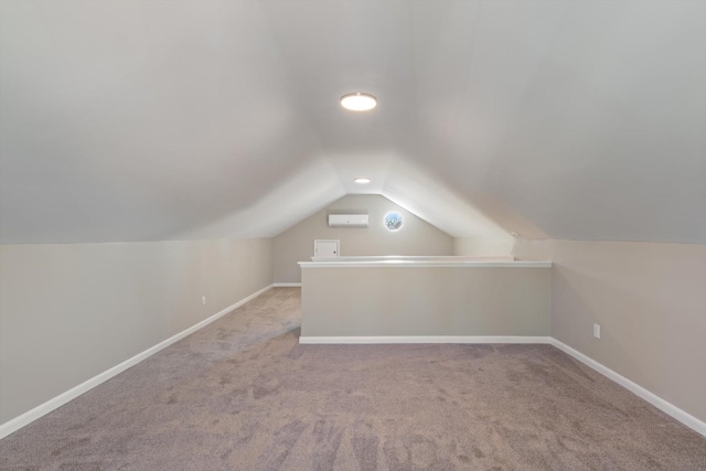 additional living space featuring light carpet, a wall unit AC, and lofted ceiling