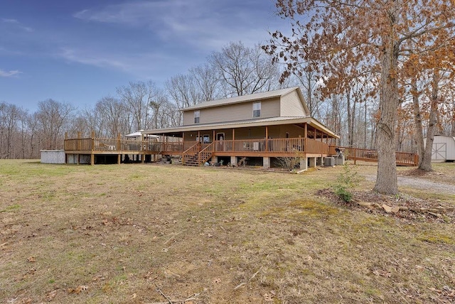 rear view of house featuring a lawn, a storage unit, and a deck