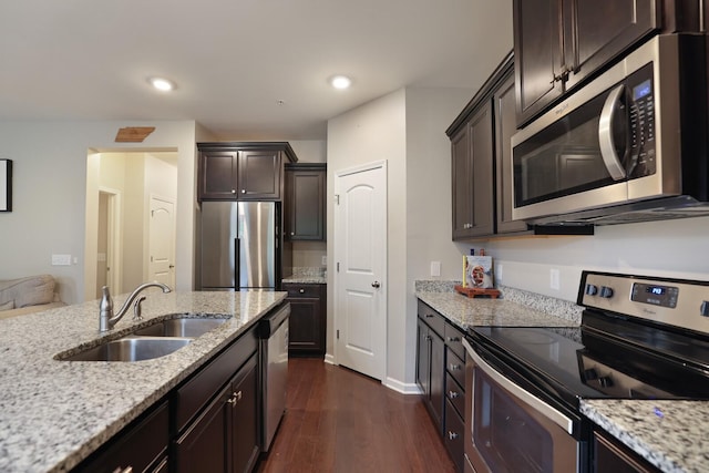 kitchen with dark hardwood / wood-style flooring, sink, light stone counters, and stainless steel appliances