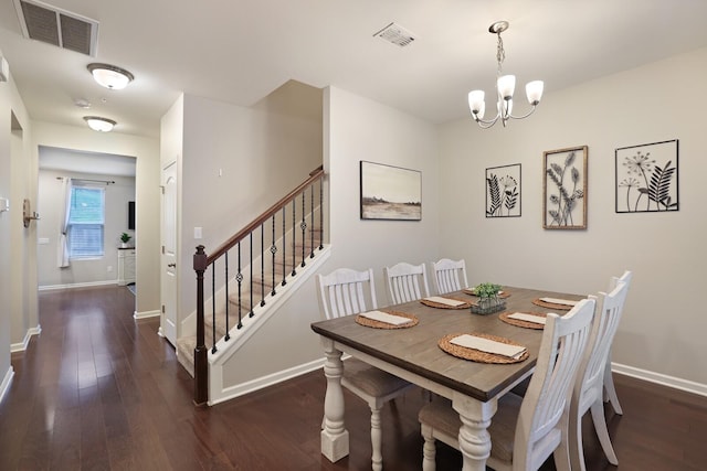 dining room with dark hardwood / wood-style flooring and an inviting chandelier