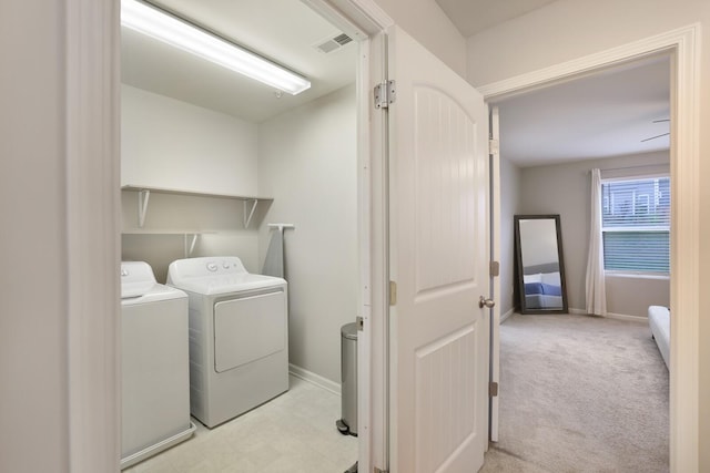 laundry room featuring washing machine and dryer and light colored carpet