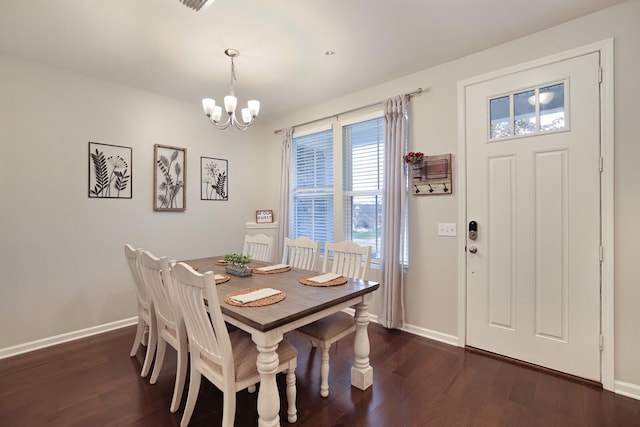 dining space featuring dark hardwood / wood-style flooring and a chandelier