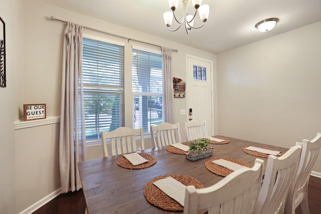 dining space featuring dark hardwood / wood-style floors and an inviting chandelier