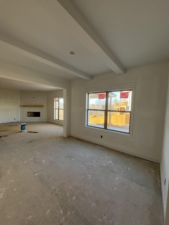 unfurnished living room featuring beamed ceiling