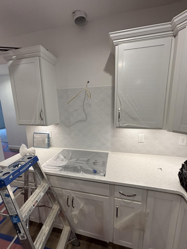 interior space featuring backsplash and light stone countertops