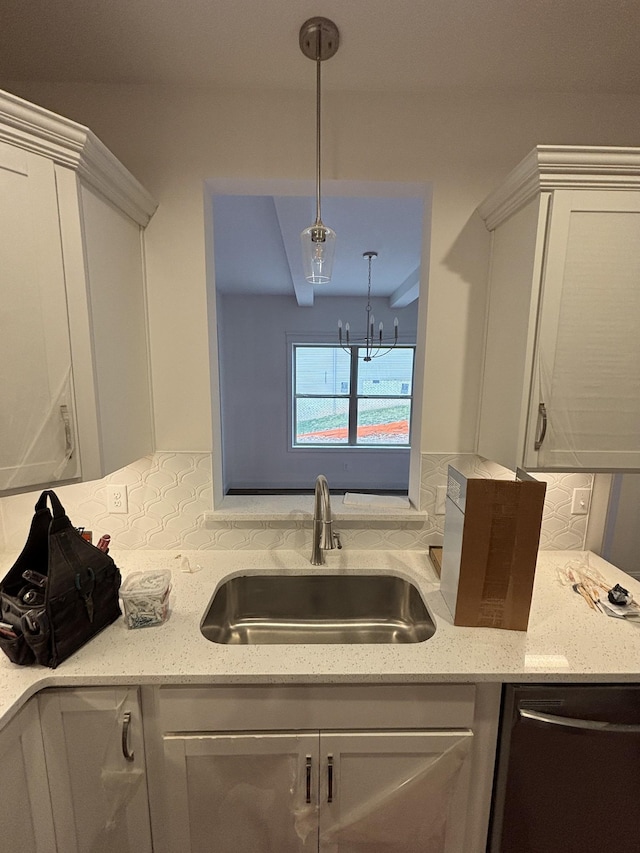 kitchen with a chandelier, dishwasher, light stone counters, hanging light fixtures, and a sink