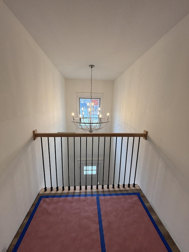 staircase with a chandelier