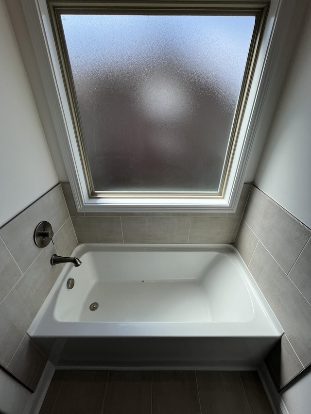 full bathroom with tile patterned flooring, plenty of natural light, and a bathtub