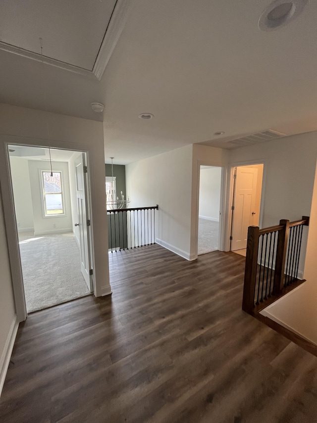 spare room with dark wood finished floors, visible vents, attic access, and baseboards