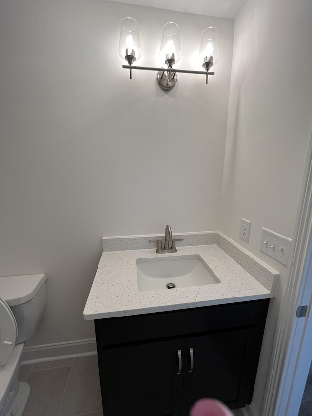 bathroom featuring baseboards, toilet, vanity, and tile patterned flooring