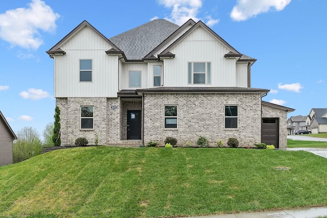 view of front of property featuring brick siding, a garage, and a front lawn