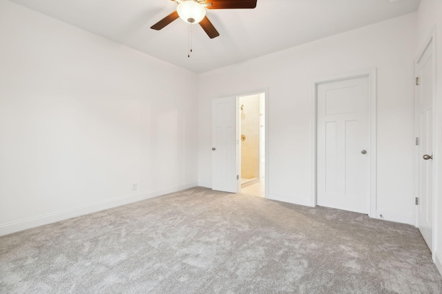 unfurnished bedroom with a ceiling fan, carpet floors, baseboards, and ensuite bathroom