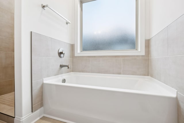 full bathroom with tile patterned floors, tile walls, and a garden tub