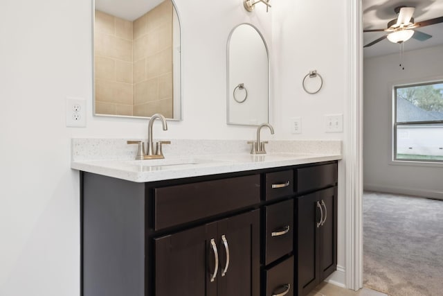 bathroom with double vanity, baseboards, a sink, and a ceiling fan