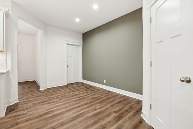 interior space featuring baseboards, visible vents, wood finished floors, and recessed lighting