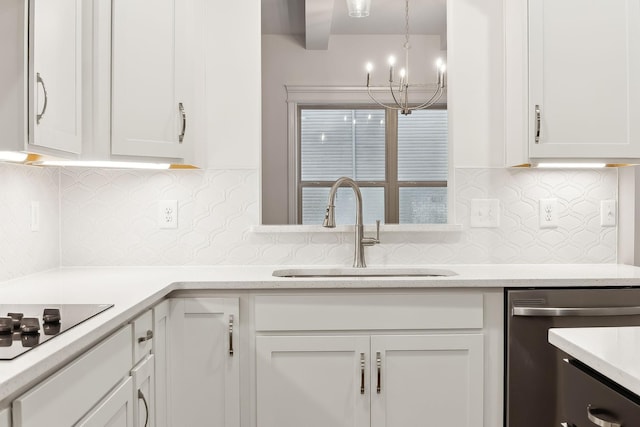 kitchen featuring black electric cooktop, white cabinetry, an inviting chandelier, stainless steel dishwasher, and a sink