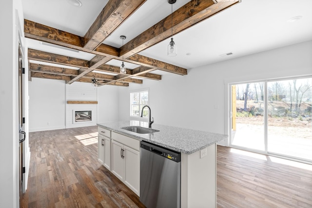 kitchen featuring white cabinetry, sink, light stone counters, stainless steel dishwasher, and pendant lighting