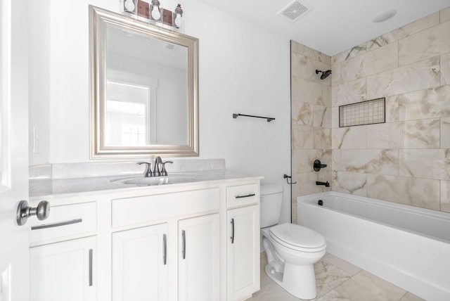 full bathroom featuring vanity, tiled shower / bath combo, and toilet