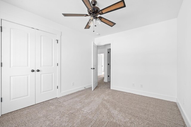 unfurnished bedroom featuring light carpet, a closet, and ceiling fan