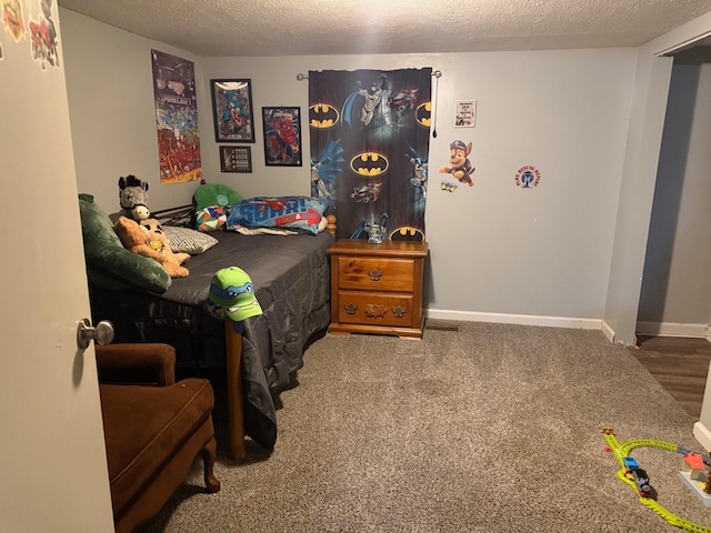 carpeted bedroom featuring baseboards and a textured ceiling