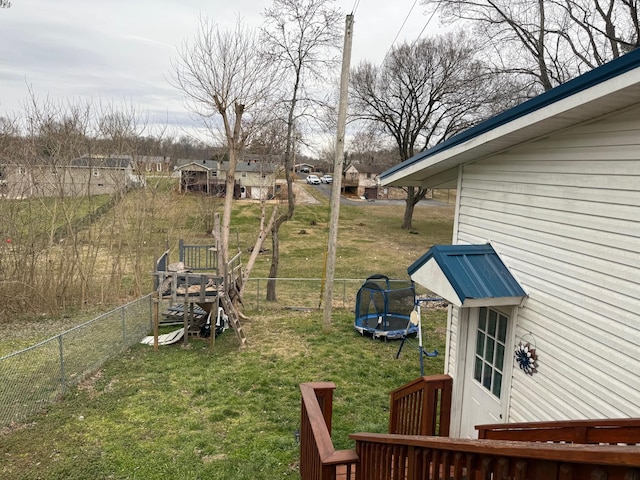 view of yard with a trampoline and fence