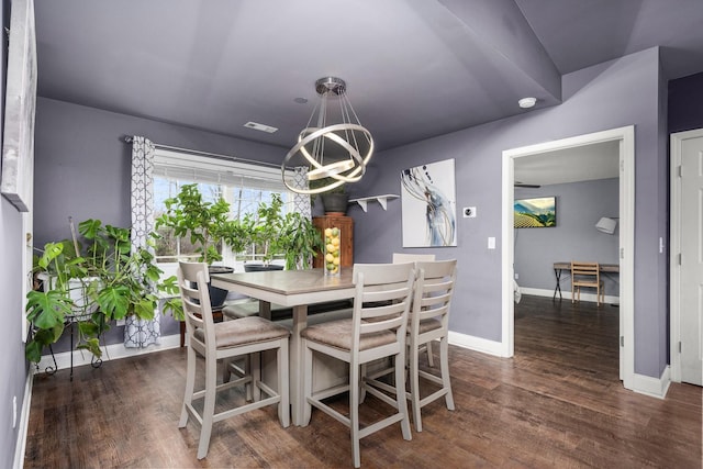 dining room with dark hardwood / wood-style floors and a chandelier