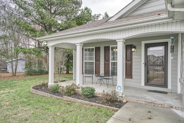 entrance to property featuring a porch and a yard