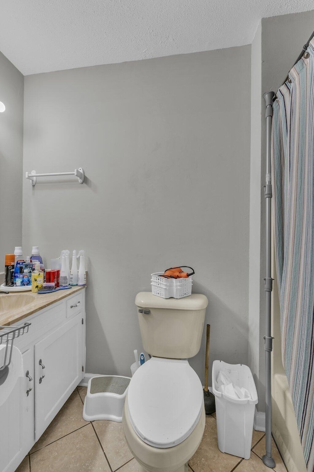 full bathroom featuring tile patterned floors, a textured ceiling, toilet, vanity, and shower / tub combo