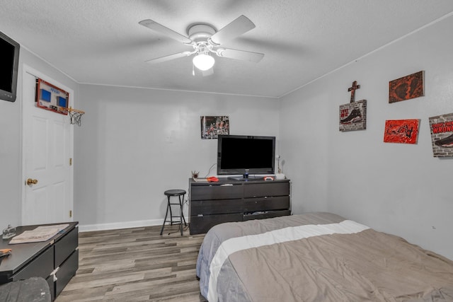 bedroom featuring hardwood / wood-style floors, a textured ceiling, and ceiling fan