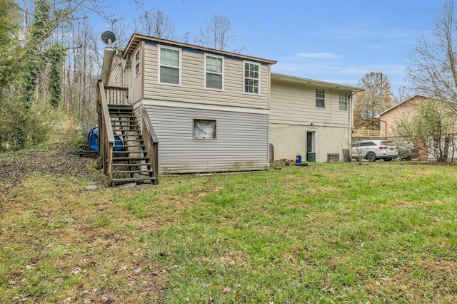 rear view of property featuring a lawn