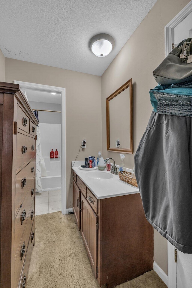 bathroom featuring vanity, a textured ceiling, and shower / bathtub combination with curtain