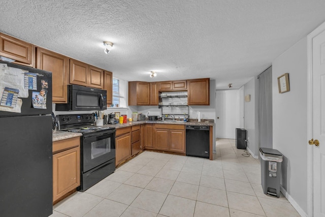 kitchen with sink, light tile patterned floors, a textured ceiling, and black appliances