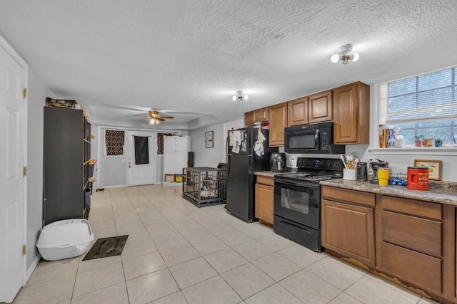 kitchen with light tile patterned floors, a textured ceiling, ceiling fan, and black appliances