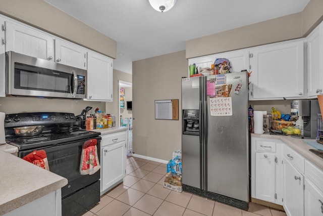 kitchen featuring appliances with stainless steel finishes, light tile patterned floors, and white cabinetry