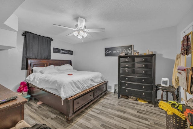 bedroom featuring ceiling fan, a textured ceiling, and light wood-type flooring