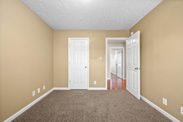 unfurnished bedroom with carpet and a textured ceiling