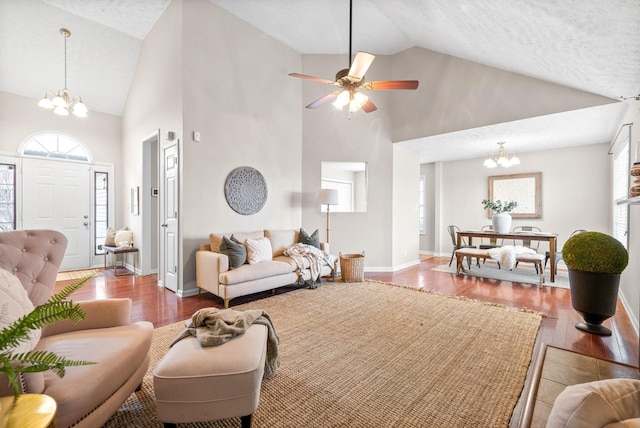 living room featuring ceiling fan with notable chandelier, hardwood / wood-style floors, and high vaulted ceiling