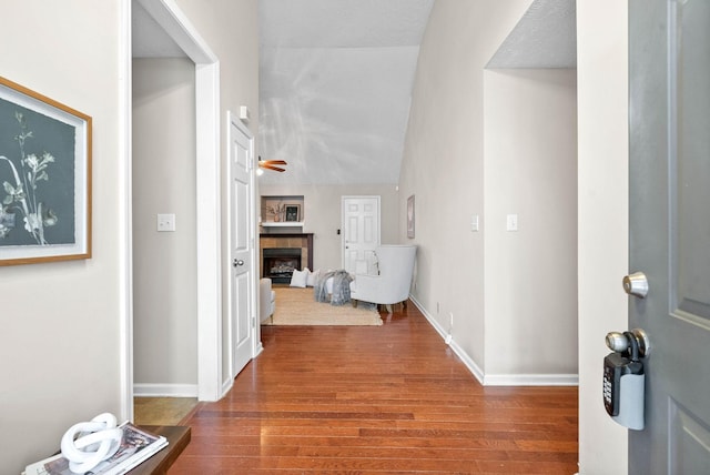 hall featuring wood-type flooring and lofted ceiling