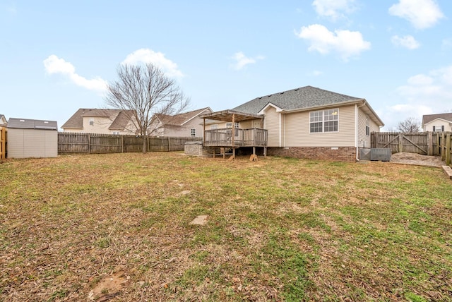 rear view of property with a wooden deck, a shed, and a lawn