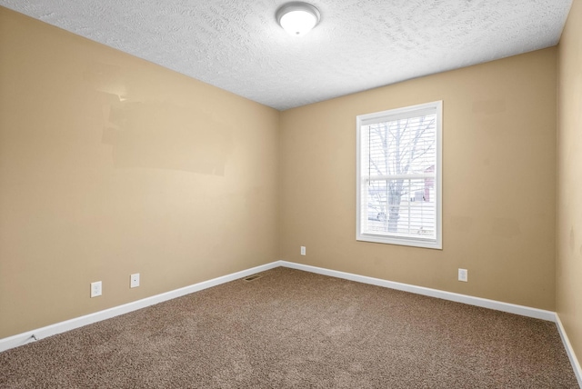 spare room featuring carpet floors and a textured ceiling