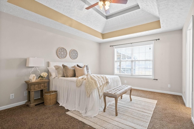 carpeted bedroom featuring ceiling fan, a raised ceiling, and a textured ceiling