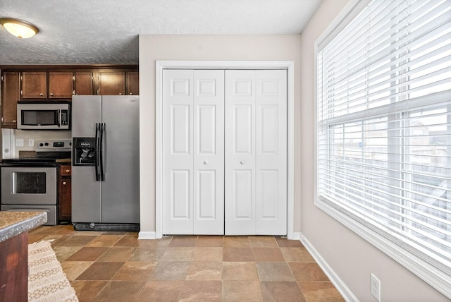 kitchen with a textured ceiling and appliances with stainless steel finishes